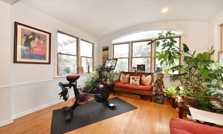 Workout room featuring lofted ceiling and light wood-type flooring