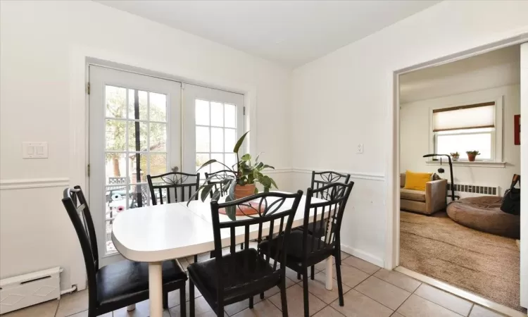 Dining room with a baseboard heating unit, light tile patterned floors, french doors, and radiator heating unit