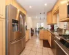 Kitchen with stainless steel appliances, light brown cabinetry, dark stone countertops, and kitchen peninsula