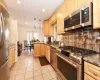 Kitchen featuring light brown cabinetry, sink, appliances with stainless steel finishes, and dark stone countertops