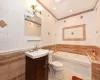 Bathroom with tile patterned floors, vanity, tile walls, toilet, and a bath