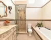 Full bathroom featuring toilet, vanity, tile patterned flooring, tile walls, and plus walk in shower