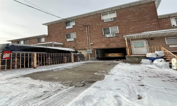 Snow covered property with a garage