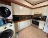 Kitchen with stacked washer / drying machine, stainless steel gas range oven, dishwasher, ornamental molding, and sink