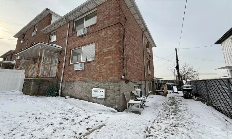 Snow covered house with a wall mounted AC