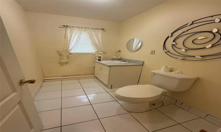 Bathroom featuring toilet, vanity, and tile patterned flooring