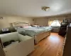 Bedroom featuring light hardwood / wood-style floors, a baseboard heating unit, and a wall mounted AC