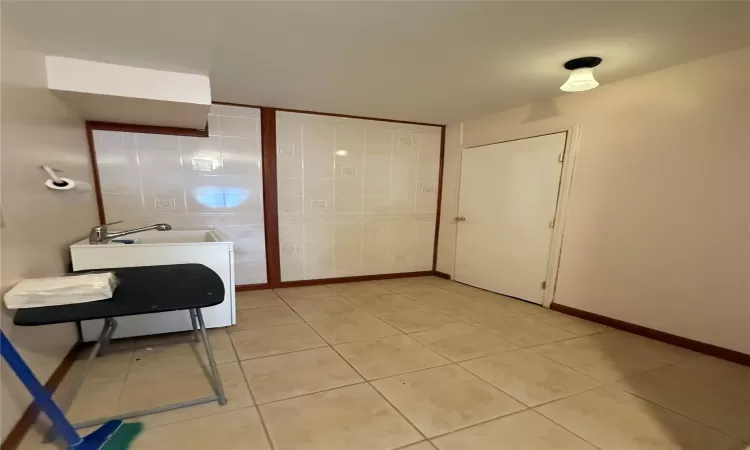 Bathroom featuring tile patterned flooring and tile walls