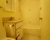 Full bathroom featuring toilet, vanity, tiled shower / bath combo, and tile patterned flooring