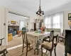 Carpeted dining area with a brick fireplace, a wealth of natural light, and a notable chandelier