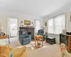 Living room featuring light carpet, a fireplace, and radiator heating unit