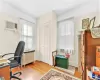 Office with radiator, an AC wall unit, and light hardwood / wood-style flooring