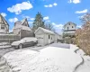 Yard layered in snow featuring an outbuilding and a garage