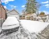 Yard covered in snow featuring a garage and an outbuilding