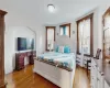 Bedroom with cooling unit, light hardwood / wood-style flooring, and a baseboard radiator