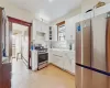 Kitchen with baseboard heating, stainless steel appliances, white cabinets, and sink