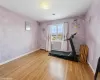 Exercise area with hardwood / wood-style flooring and a baseboard heating unit