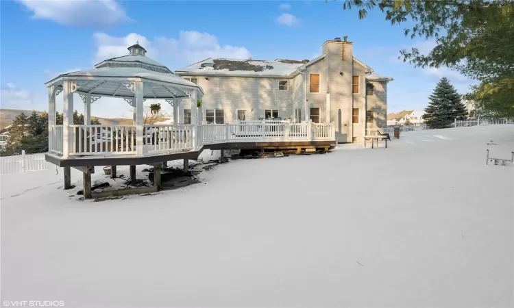 Snow covered property with a wooden deck and a gazebo