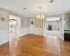 Unfurnished dining area featuring crown molding, light hardwood / wood-style floors, and a notable chandelier