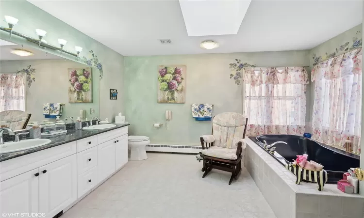 Primary bath featuring whirlpool tub, double vanity, shower and heat lamp