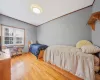 Bedroom with crown molding and wood-type flooring