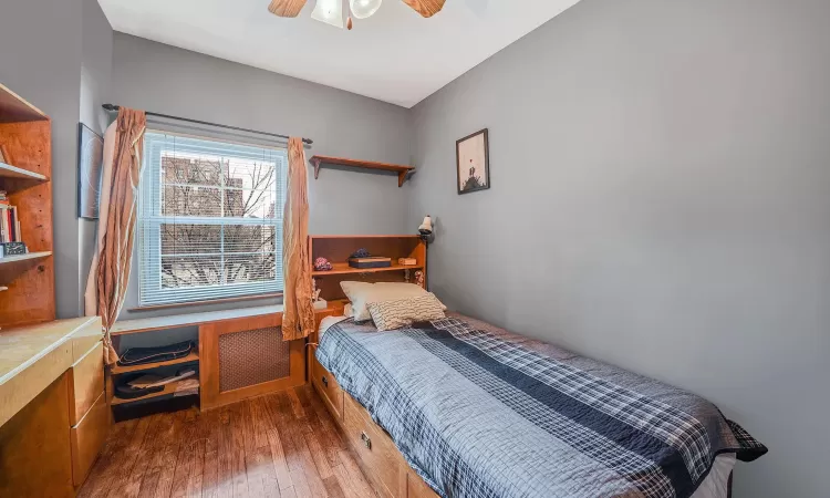 Bedroom featuring ceiling fan and dark hardwood / wood-style flooring