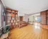 Unfurnished living room featuring crown molding, light hardwood / wood-style flooring, an AC wall unit, and a notable chandelier