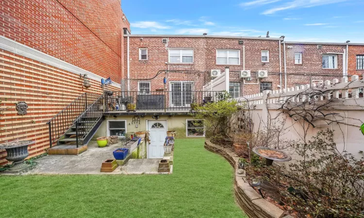 Back of property featuring central AC and a yard