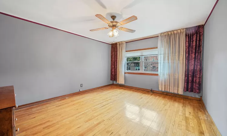 Unfurnished room with ceiling fan, crown molding, and light hardwood / wood-style flooring