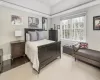 Bedroom with crown molding, light hardwood / wood-style floors, and a tray ceiling