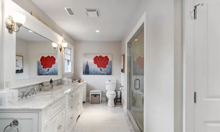 Bathroom with toilet, a shower with shower door, and vanity