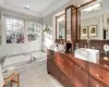 Bathroom featuring a bath, crown molding, and vanity