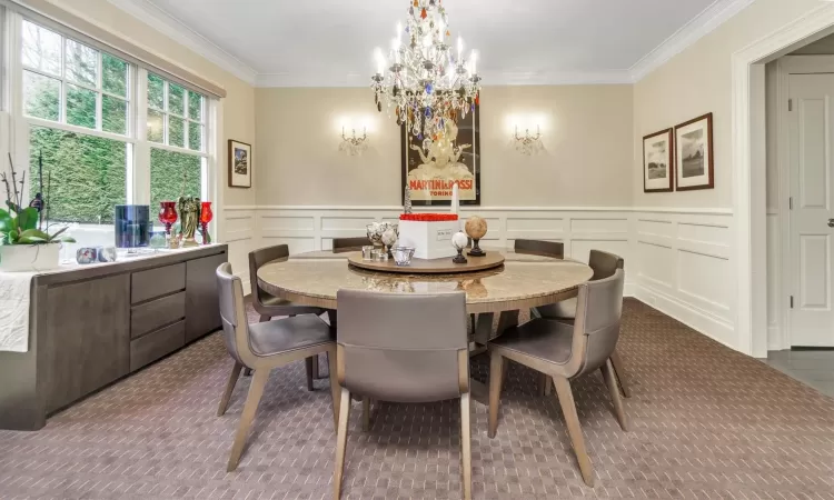 Dining space featuring ornamental molding and a chandelier