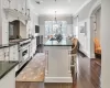 Kitchen featuring designer stove, white cabinets, a breakfast bar, and hanging light fixtures