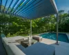 View of pool with a pergola and a wooden deck