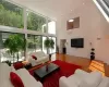 Living room with hardwood / wood-style flooring, a high ceiling, a skylight, and a healthy amount of sunlight