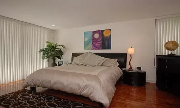 Bedroom with dark wood-type flooring