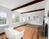 Living room with radiator, dark hardwood / wood-style flooring, and beamed ceiling