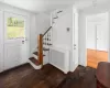 Stairs featuring radiator heating unit and hardwood / wood-style floors