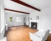 Living room with beam ceiling, dark hardwood / wood-style flooring, and wood ceiling