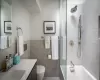 Full bathroom with tile walls, tiled shower / bath combo, vanity, and toilet