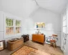 Living area featuring track lighting, hardwood / wood-style floors, and lofted ceiling