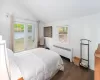 Bedroom featuring radiator, vaulted ceiling, dark hardwood / wood-style flooring, and multiple windows