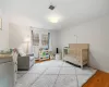 Bedroom featuring a nursery area and light hardwood / wood-style floors