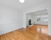 Unfurnished living room featuring a baseboard heating unit, ornamental molding, and light hardwood / wood-style floors