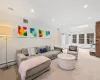 Living room featuring baseboard heating, light colored carpet, and lofted ceiling with skylight