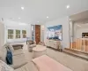 Living room featuring baseboard heating, a skylight, a fireplace, and light colored carpet