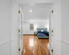 Bedroom featuring a baseboard heating unit, hardwood / wood-style flooring, and french doors