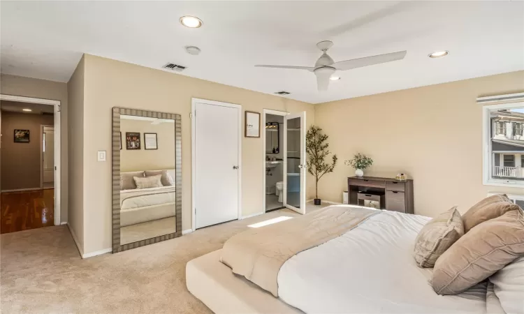 Carpeted bedroom featuring ceiling fan