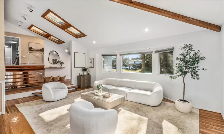 Living room with beamed vaulted ceiling with skylights